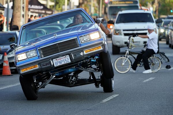 Лоурайдер едет на трехколесном автомобиле по бульвару Сансет в районе Эхо-Парк в Лос-Анджелесе 