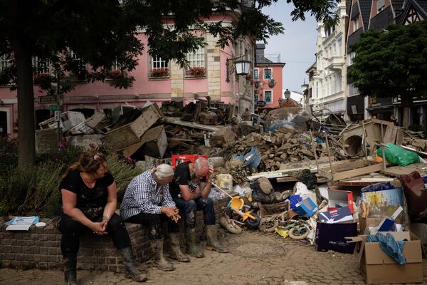 Люди отдыхают от уборки мусора в результате наводнения в Бад-Нойенар-Арвайлере, Германия