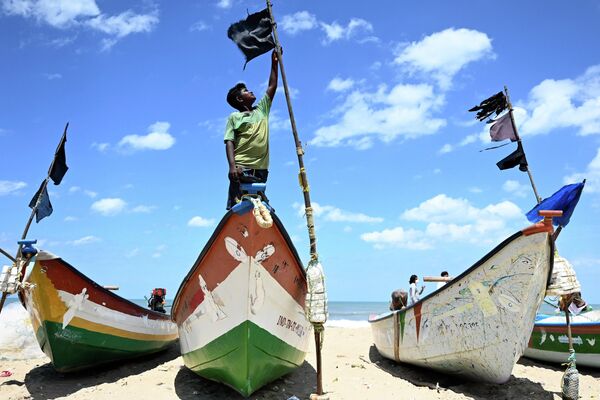 Рыбак вешает черный флаг на свою лодку в Ченнаи 