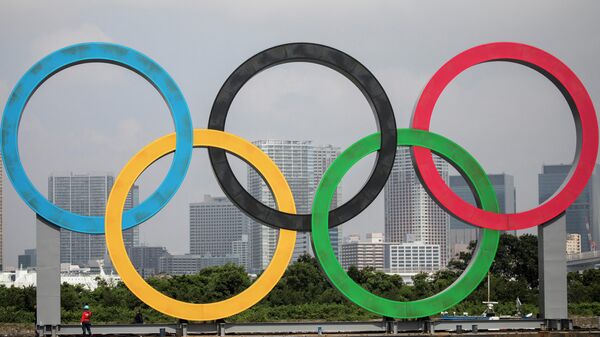 A large size Olympic rings symbol is seen at Tokyo Waterfront in the waters of Odaiba Marine Park on August 6, 2020, while being transferred back to the factory where it was manufactured for a safety inspection and to receive maintenance. (Photo by Behrouz MEHRI / AFP)