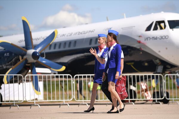 Стюардессы на фоне пассажирского самолета Ил-114-300 на МАКС-2021