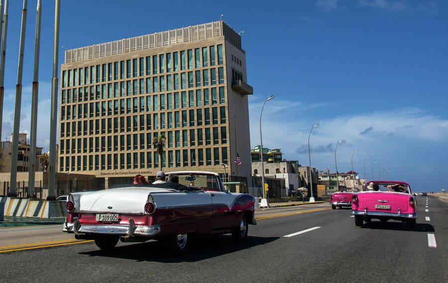 Ретро-автомобили с туристами около посольства США в Гаване, Куба