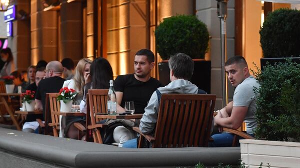 Посетители на летней веранде кафе на Большой Бронной улице в Москве