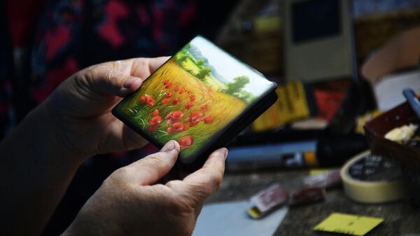 Мастер-художник расписывает будущую шкатулку в мастерской Федоскинской фабрики миниатюрной живописи в Московской области
