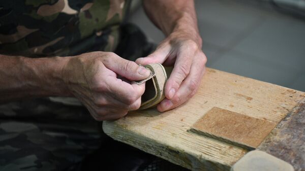 Работник по изготовлению шкатулок в мастерской Федоскинской фабрики миниатюрной живописи в Московской области