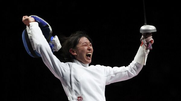 Китайская шпажистка Сунь Ивэнь празднует победу на Олимпийских играх.