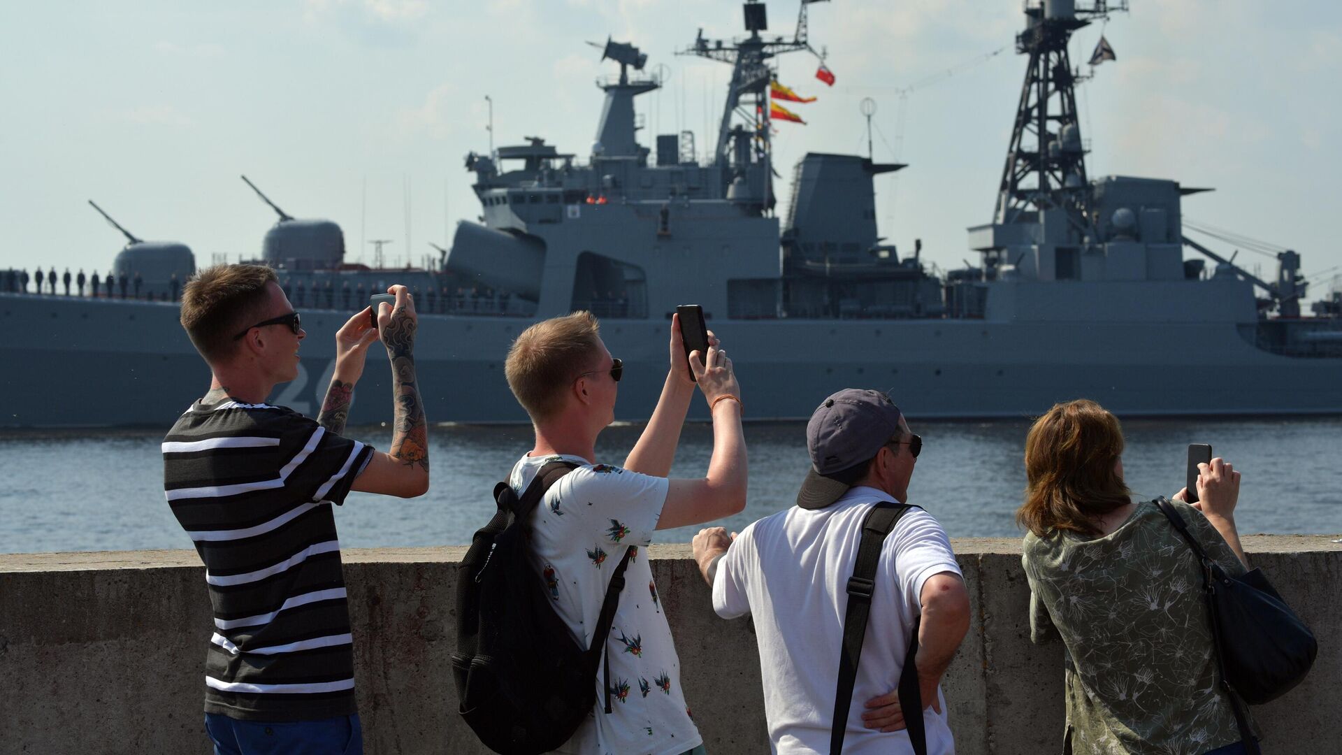 Люди на набережной наблюдают за подготовкой кораблей ВМФ РФ к параду в Кронштадте - РИА Новости, 1920, 25.07.2021