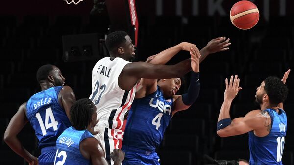 France's Moustapha Fall (3L) fights for the ball with USA's Keldon Johnson (2R) during the men's preliminary round group A basketball match between France and USA during the Tokyo 2020 Olympic Games at the Saitama Super Arena in Saitama on July 25, 2021. (Photo by Aris MESSINIS / AFP)