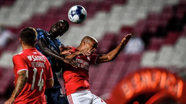 Benfica's Portuguese midfielder Joao Mario (R) heads the ball with Marseille's French midfielder Pape Gueye during an international club friendly football match between SL Benfica and Olympique de Marseille at the Luz stadium in Lisbon on July 25, 2021. (Photo by PATRICIA DE MELO MOREIRA / AFP)