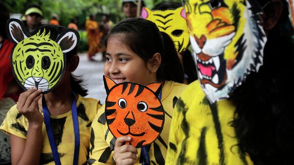 Школьники в масках тигра во время митинга, посвященному Международному дню тигра, в зоопарке Алипор в Калькутте