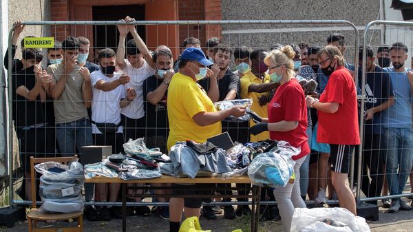 Литовцы продают вещи мигрантам в лагере беженцев в селе Веребежай в Литве
