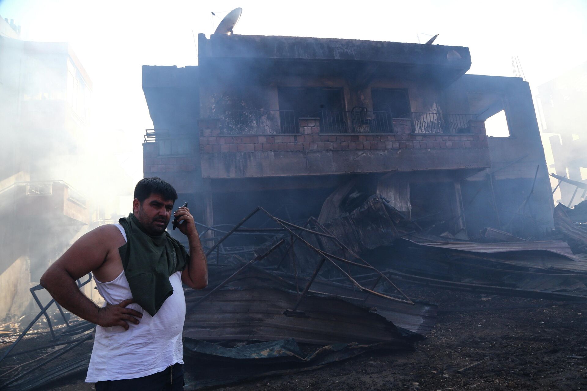 Мужчина возле сгоревшего дома в результате лесного пожара в Анталье, Турция - РИА Новости, 1920, 29.07.2021