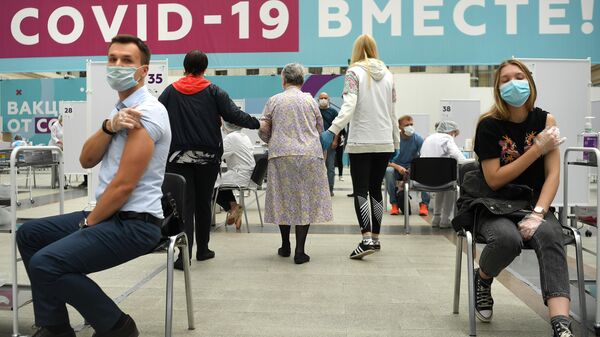 Посетители делают прививки в центре вакцинации от COVID-19 в Гостином дворе в Москве