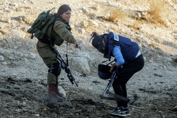  Девушка — солдат Израильской Армии распыляет газовый баллончик на журналиста во время акции протеста против израильских поселений недалеко от Тубаса на оккупированном Израилем Западном берегу 