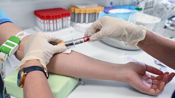 Медицинский работник проводит забор крови на антитела к коронавирусу COVID-19