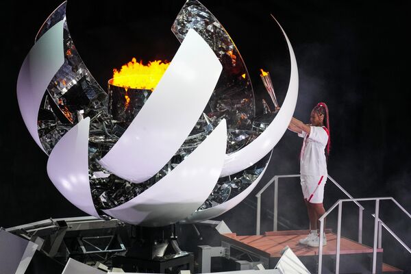Теннисистка Наоми Осака зажигает олимпийский огонь на церемонии открытия XXXII летних Олимпийских игр в Токио