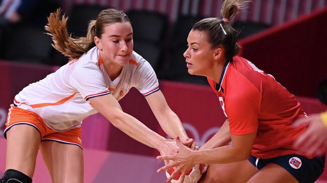 Netherlands' left wing Bo van Wetering (L) challenges Norway's right back Nora Moerk during the women's preliminary round group A handball match between Norway and The Netherlands of the Tokyo 2020 Olympic Games at the Yoyogi National Stadium in Tokyo on July 31, 2021. (Photo by Daniel LEAL-OLIVAS / AFP)