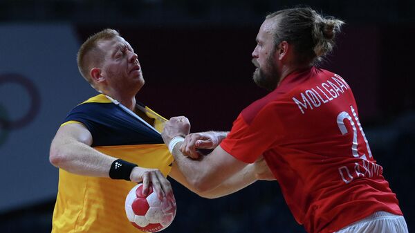 Sweden's centre back Jim Gottfridsson (L) vies with Denmark's left back Henrik Mollgard during the men's preliminary round group B handball match between Denmark and Sweden of the Tokyo 2020 Olympic Games at the Yoyogi National Stadium in Tokyo on August 1, 2021. (Photo by Franck FIFE / AFP)