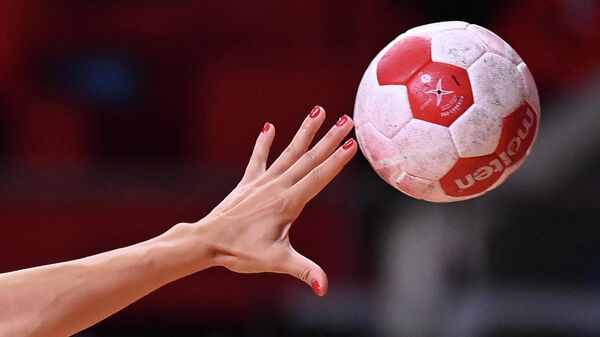 A handball player passes the ball during the women's preliminary round group A handball match between Japan and Montenegro of the Tokyo 2020 Olympic Games at the Yoyogi National Stadium in Tokyo on July 27, 2021. (Photo by Daniel LEAL-OLIVAS / AFP)