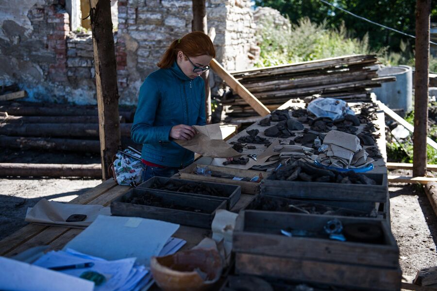 Девушка рассматривает археологические находки в Пскове