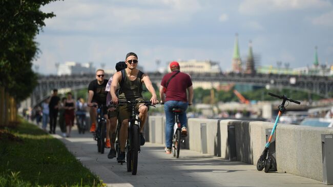 Люди катаются на велосипедах на Фрунзенской набережной в Москве