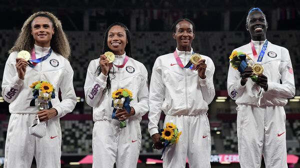 Gold medallists Team USA, USA's Sydney Mclaughlin, USA's Allyson Felix, USA's Dalilah Muhammad and USA's Athing Mu celebrate on the podium during the Victory Ceremony for the women's 4x400m relay event during the Tokyo 2020 Olympic Games at the Olympic Stadium in Tokyo on August 7, 2021. (Photo by Javier SORIANO / AFP)