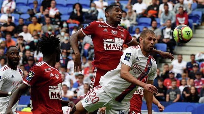 Brest's French defender Pierre-Gabriel Ronael (C) fights for the ball with Lyon's Algerian forward Islam Slimani (R) during the French L1 football match between Lyon (OL) and Brest (SB), at the Groupama stadium in Decine-Charpieu near Lyon on August 7, 2021. (Photo by JEAN-PHILIPPE KSIAZEK / AFP)