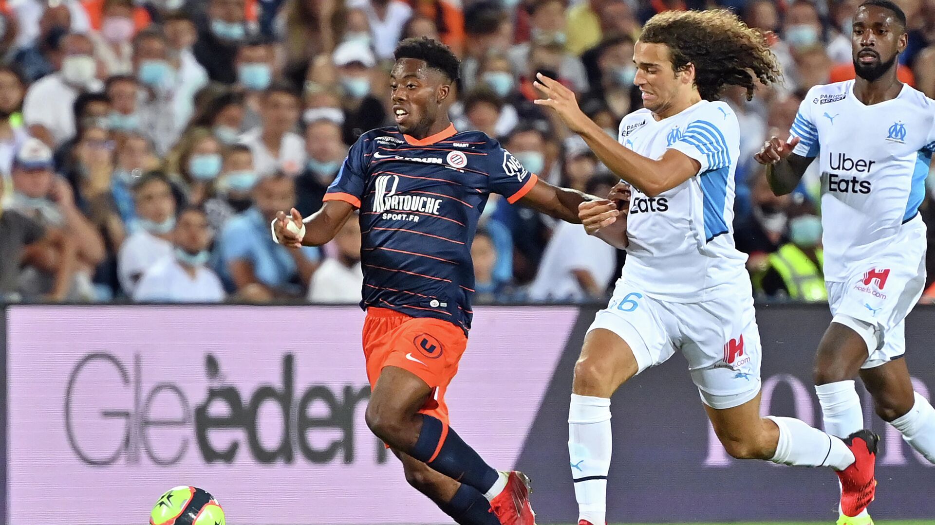 Montpellier's French forward Elye Wahi (L) fights for the ball with Marseille's French defender Matteo Guendouzi (R) during the French L1 football match between Montpellier and Marseille at the Mosson stadium in Montpellier, southern France on August 8, 2021. (Photo by Pascal GUYOT / AFP) - РИА Новости, 1920, 09.08.2021