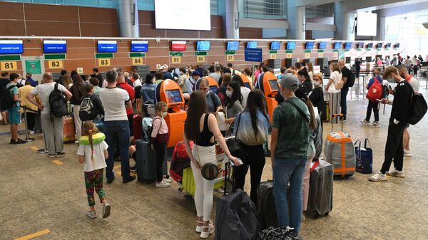 Пассажиры возле стоек регистрации в аэропорту Шереметьево в Москве
