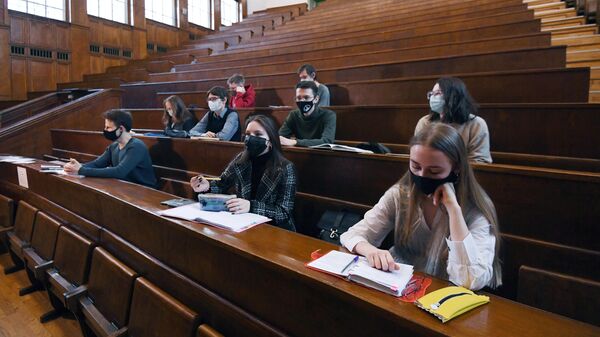 Студенты в защитных масках во время лекции в аудитории Московского государственного университета имени М. В. Ломоносова 