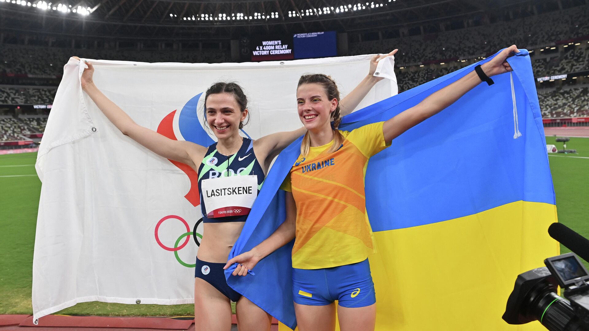 Gold medallist Russia's Mariya Lasitskene (L) and bronze medallist Ukraine's Yaroslava Mahuchikh celebrate after the women's high jump final during the Tokyo 2020 Olympic Games at the Olympic Stadium in Tokyo on August 7, 2021. (Photo by Andrej ISAKOVIC / AFP) - РИА Новости, 1920, 09.08.2021