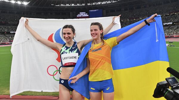 Gold medallist Russia's Mariya Lasitskene (L) and bronze medallist Ukraine's Yaroslava Mahuchikh celebrate after the women's high jump final during the Tokyo 2020 Olympic Games at the Olympic Stadium in Tokyo on August 7, 2021. (Photo by Andrej ISAKOVIC / AFP)