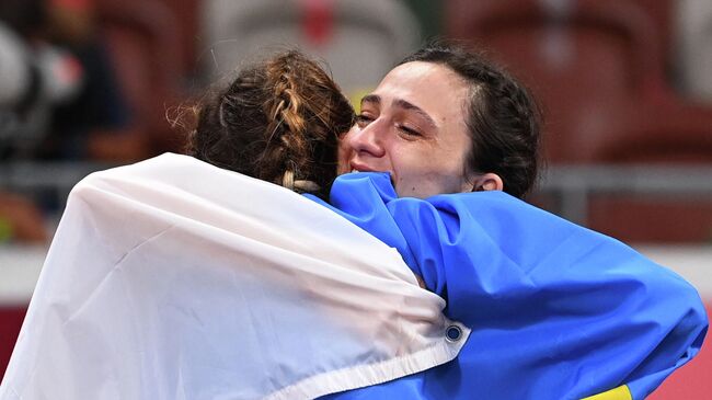 Tokyo 2020 Olympics - Athletics - Women's High Jump - Final - Olympic Stadium, Tokyo, Japan - August 7, 2021. Gold medallist Maria Lasitskene of the Russian Olympic Committee celebrates with bronze medallist, Yaroslava Mahuchikh of Ukraine REUTERS/Dylan Martinez