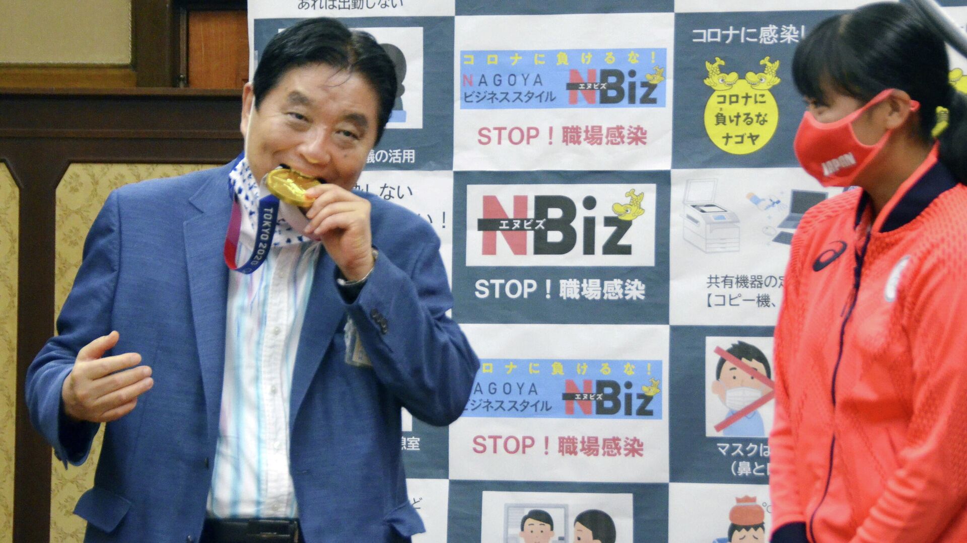 Мэр города Нагоя Такаси Кавамура кусает золотую медаль японской софтболистки - РИА Новости, 1920, 12.08.2021