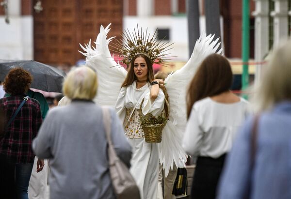 Женщина в костюме ангела на Никольской улице в центре Москвы