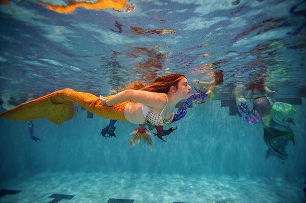 Девушка в костюме русалки во время Mermagica Con в водном центре Freedom Aquatic Center в Манассас, штат Вирджиния