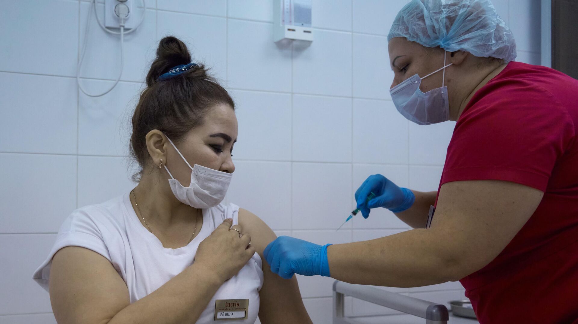 Медицинский сотрудник делает женщине прививку от COVID-19 в Санкт-Петербурге - РИА Новости, 1920, 25.05.2023
