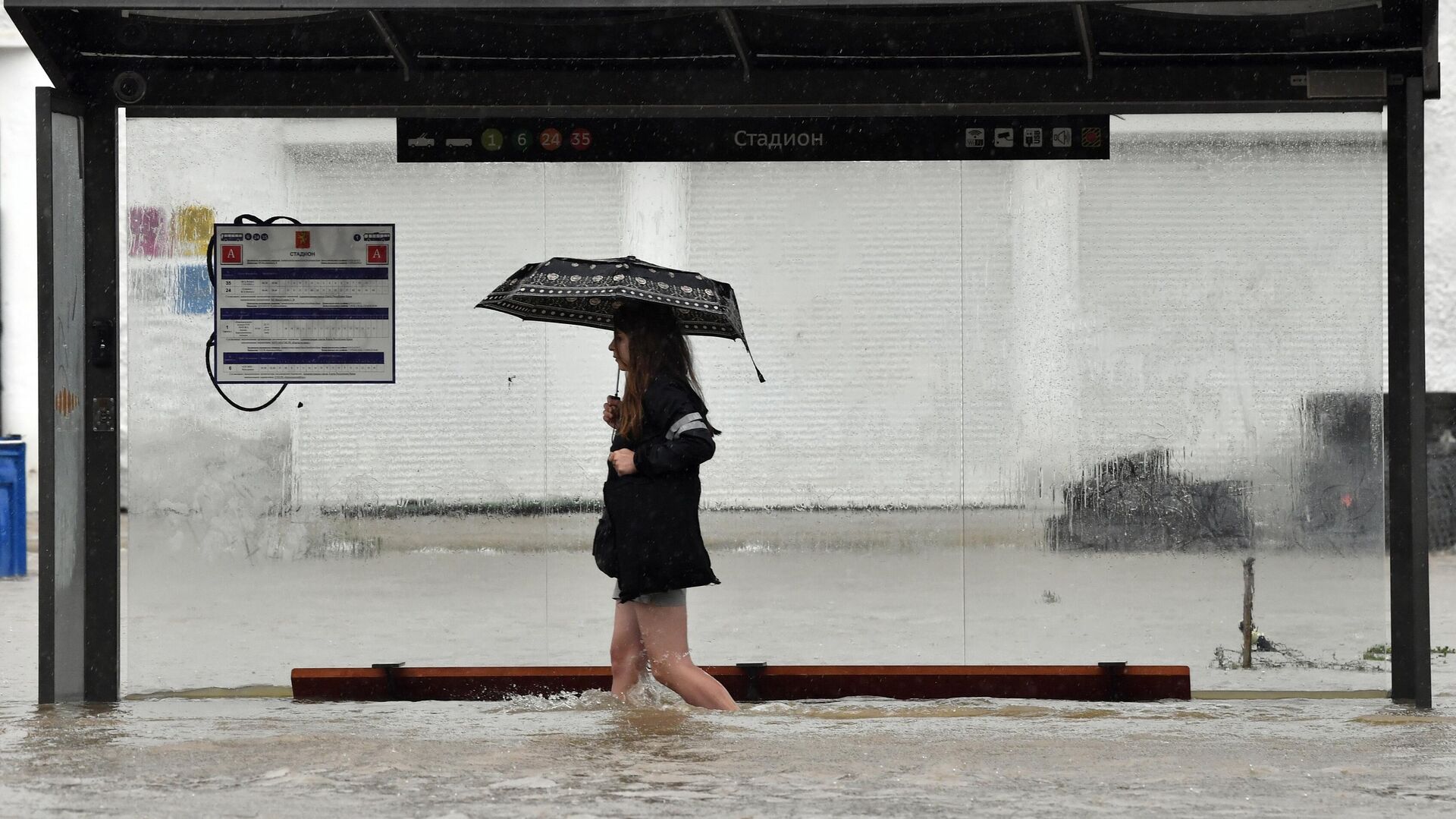 Девушка на подтопленной автобусной остановке в результате ливневых дождей улице в Керчи - РИА Новости, 1920, 13.08.2021