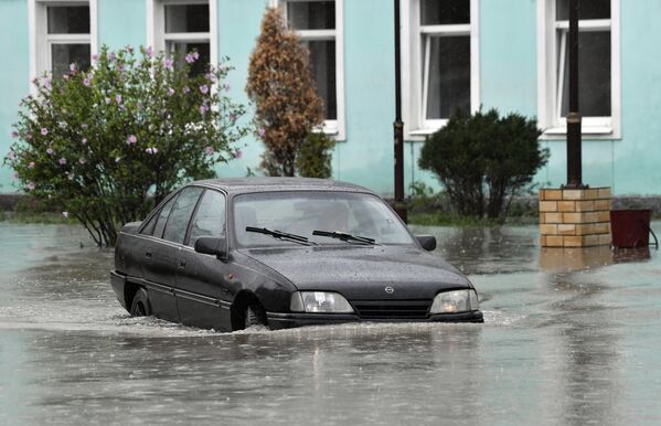 Автомобиль на подтопленной в результате ливневых дождей улице в Керчи