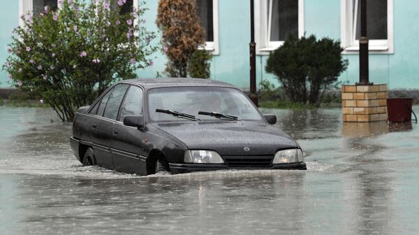 Автомобиль на подтопленной в результате ливневых дождей улице в Керчи