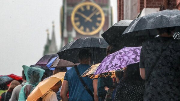 Люди под зонтами на Красной площади