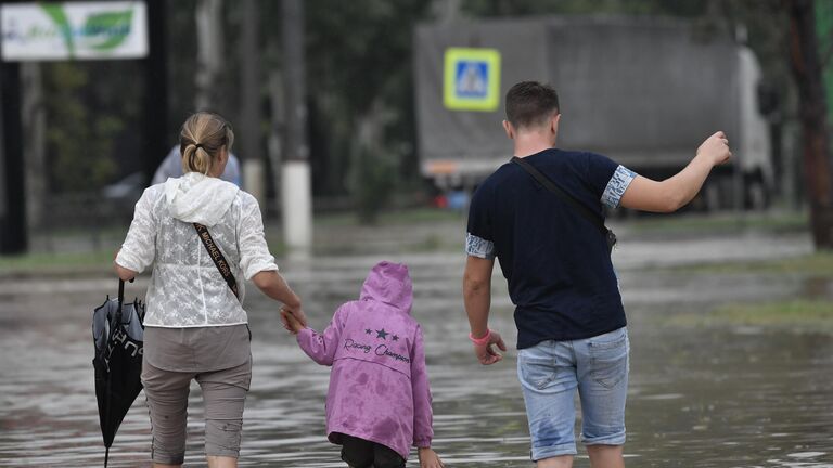 Прохожие на подтопленной в результате ливневых дождей улице в Керчи