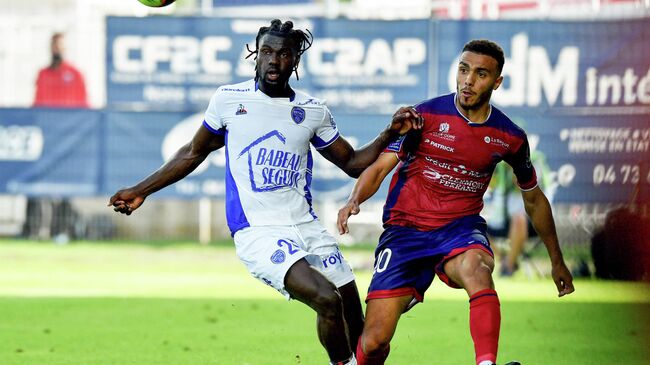 Troyes' Guinean forward Mama Balde (L) fights for the ball with Clermont's French defender Akim Zedadka (R) during  the French L1 football match between Clermont (CF63) and Troyes (ESTAC) , at the Gabriel-Montpied stadium in Clermont-Ferrand on August 15, 2021. (Photo by JEAN-PHILIPPE KSIAZEK / AFP)