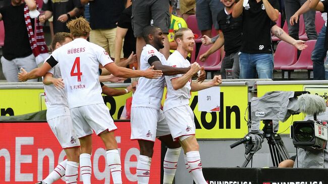 Cologne's Austrian midfielder Florian Kainz (R) celebrates scoring the 3-1 goal with teammates during the German first division Bundesliga football match between FC Cologne and Hertha BSC Berlin in Cologne, western Germany, on August 15, 2021. (Photo by UWE KRAFT / AFP) / DFL REGULATIONS PROHIBIT ANY USE OF PHOTOGRAPHS AS IMAGE SEQUENCES AND/OR QUASI-VIDEO