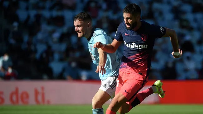 Atletico Madrid's Belgian midfielder Yannick Ferreira-Carrasco (R) fights for the ball with Celta Vigo's Spanish midfielder Javi Galan during the Spanish League football match between Celta Vigo and Atletico Madrid at the Balaidos stadium in Vigo on August 15, 2021. (Photo by MIGUEL RIOPA / AFP)