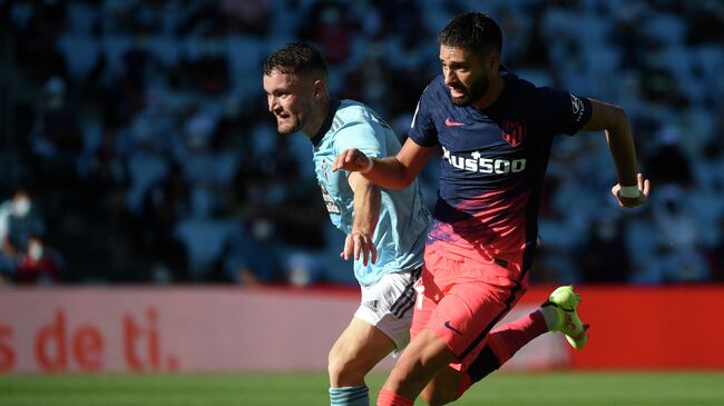 Atletico Madrid's Belgian midfielder Yannick Ferreira-Carrasco (R) fights for the ball with Celta Vigo's Spanish midfielder Javi Galan during the Spanish League football match between Celta Vigo and Atletico Madrid at the Balaidos stadium in Vigo on August 15, 2021. (Photo by MIGUEL RIOPA / AFP)