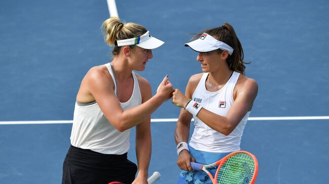 MONTREAL, QC - AUGUST 13: Luisa Stefani (R) of Brazil and Gabriela Dabrowski (L) of Canada encourage each other during their Womens Doubles Quarterfinals match against Elise Mertens of Belgium and Aryna Sabalenka of Belarus on Day Five of the National Bank Open presented by Rogers at IGA Stadium on August 13, 2021 in Montreal, Canada.   Minas Panagiotakis/Getty Images/AFP (Photo by Minas Panagiotakis / GETTY IMAGES NORTH AMERICA / Getty Images via AFP)