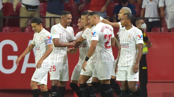Sevilla's Argentinian forward Erik Lamela (C) celebrates with teammates after scoring during the Spanish League football match between Sevilla and Rayo Vallecano at the Ramon Sanchez Pizjuan stadium in Sevilla on August 15, 2021. (Photo by CRISTINA QUICLER / AFP)