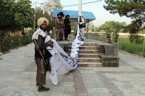 Боевики Талибана* поднимают свой флаг у резиденции губернатора провинции Газни, юго-восток Афганистана