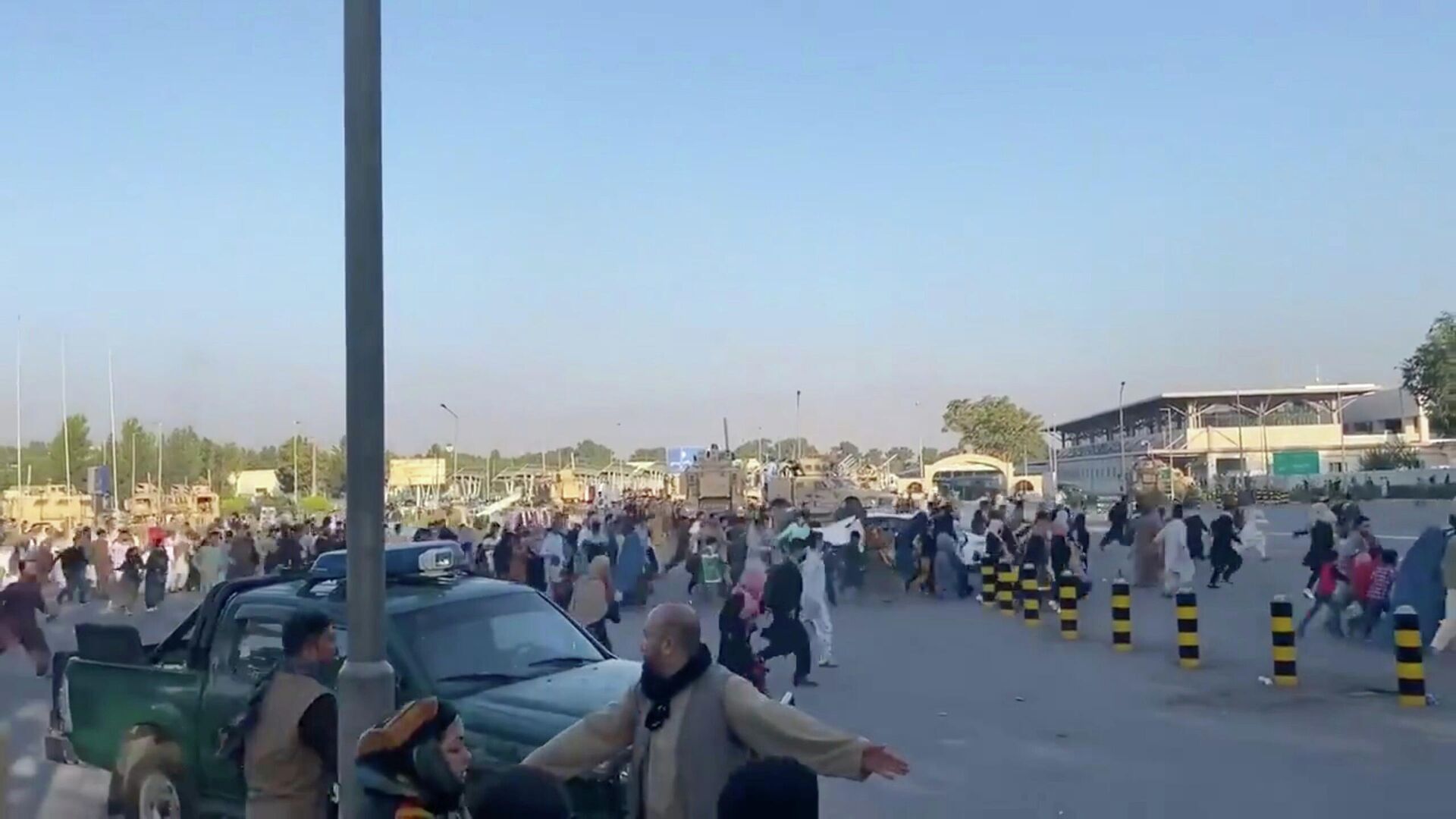 Толпа людей бежит к терминалу аэропорта Кабула после того, как боевики Талибана*  взяли под контроль президентский дворец - РИА Новости, 1920, 16.08.2021